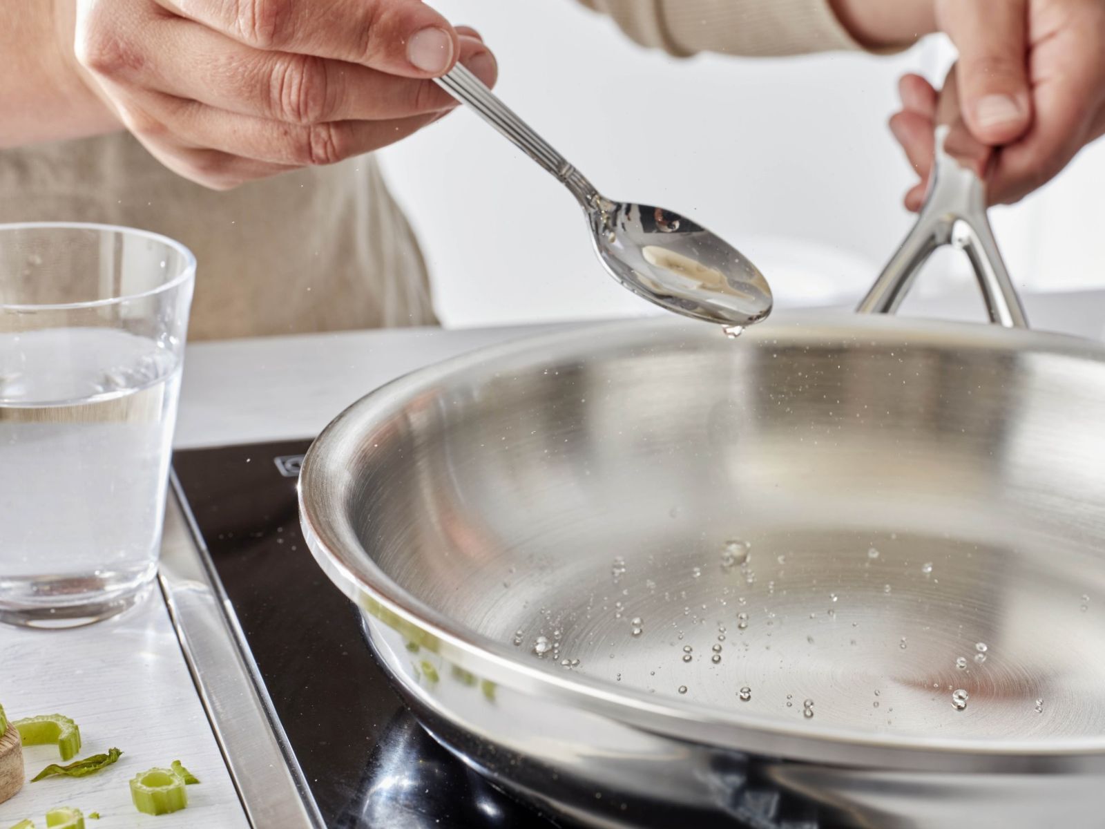 Gouttes d’eau roulant dans une poêle en inox lors du test de la goutte